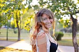 Horizontal closeup portrait of a beautiful long-haired young woman on a background of nature