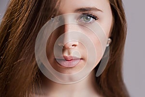 Horizontal closeup portrait of a beautiful young woman with clean skin, long eyelashes and natural beauty, fresh face