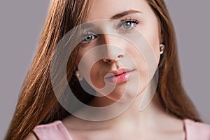 Horizontal closeup portrait of a beautiful young woman with clean skin, long eyelashes and natural beauty, fresh face. Green eyes