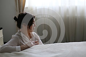 Horizontal closeup portrait profile of a sad girl on a window background