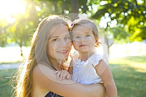 Horizontal closeup portrait of a thirty year old woman with one year old daughter in her arms