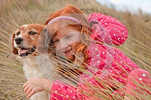 Horizontal format colour shot of red haired girl with red haired dog, Gisborne, New Zealand