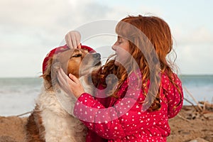 Horizontal format colour shot of red haired girl with red haired dog, Gisborne, New Zealand