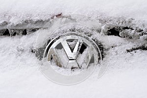 Horizontal front view of Volkswagen logo covered in snow