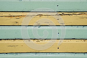 Horizontal green and yellow stripes painted on timber cladding.
