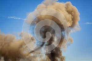 Horizontal image of Column of smoke with tornado against blue sky from munitions explosion photo