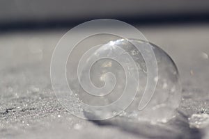 Horizontal image of frozen bubble in sparkly snow