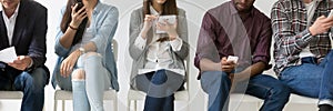 Horizontal image multiracial people sitting in row using electronic devices