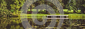 Horizontal image panoramic scenic view summer green landscape with picturesque forest lush lawn wooden pier dock for boats