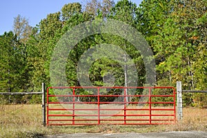 horizontal image of a red entry gate to a field
