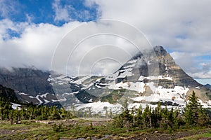 Horizontal image of Sinopah mountain half covered with snow and trees in Glacier National Park photo