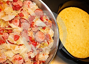 Horizontal image of southern style fried cabbage, onions, sausage and tomatoes