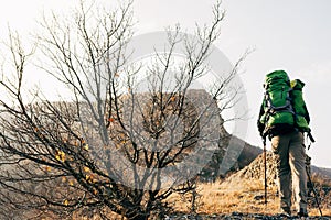 Horizontal landscape image of traveler bearded man trekking and mountaineering during his journey.