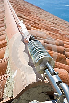 Horizontal lifeline fall protection system with inox stainless cable on terracotta roof used to prevent the danger of falling