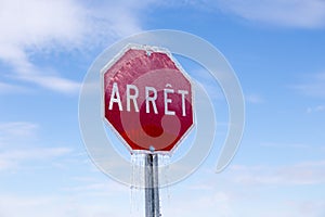 Horizontal low angle view of French stop sign encased in ice after ice storm