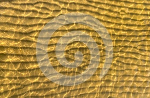 A horizontal pattern of golden sand created by waves on the coast of the resort in Estonia