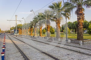 Horizontal perspective shot of tramway in movement with pedestrian stones at sunset time in Izmir at Turkey