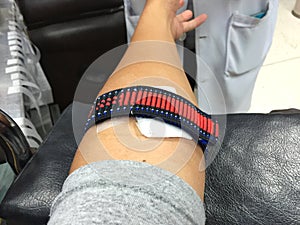 Horizontal photo of arm with red textile elastic band after bloo