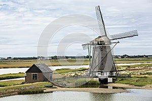 Horizontal photo of the polder windmill `Het Noord` on wadden sea island Texel in the Netherlands with a blue sky and some clouds