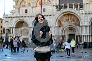 Horizontal photo of a smiling european tourist girl on Piazza San Marco