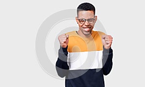 Horizontal portrait of African American male student or employee fists clenched with winning expression posing on white background