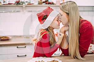 Horizontal portrait of mother and daughter kissing