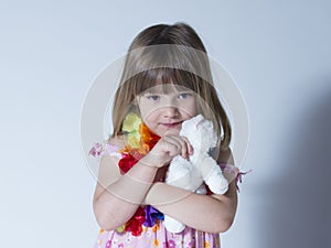 Horizontal portrait of pretty little girl dressed in floral dress and silk flower garland