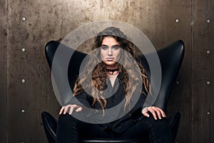Horizontal portrait of a reputable young woman in the black chair. photo