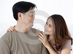 Horizontal portrait shot of senior Asian lover couple wearing eyeglasses embracing together. Wife stands behind her husband to hug