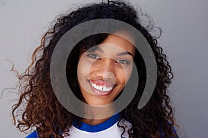 Horizontal portrait of smiling young black woman against gray wall