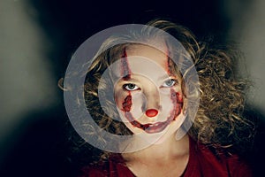 Horizontal portrait of a teenage girl with ugly clown make up. Halloween , nightmares concept.