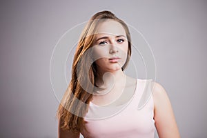 Horizontal portrait of a unhappy woman on gray background