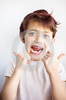 Horizontal portrait of 7 years old unhappy child in white t-shirt flossing his teeth on white background isolated. Healthcare and