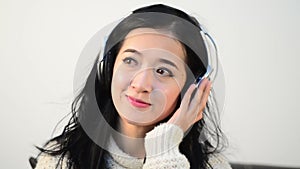 Horizontal shot of Asian woman teenager listing love music with big Headphone