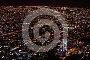 Horizontal shot of the city of Bogota at dusk from Monserrate, with night lights and the Colpatria skyscraper on the lower side of photo