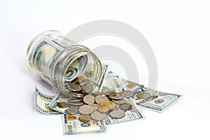 Horizontal shot of coins spilling from coin jar