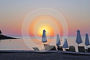 Horizontal shot. Empty beach in the evening at sunset. . Umbrellas Silhouettes and coastline.