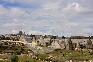 Horizontal shot of fairy chimneys of Cappadocia in Turkey in spring with green grass and small trees shot on cloudy days