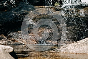 Horizontal shot of fresh, pure water flowing over rocks