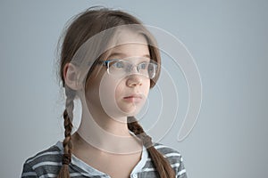 Horizontal shot of a Girl teenager with glasses and two braids. Portrait of the blonde girl