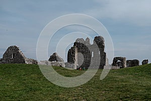 Horizontal shot of historical building ruins in the field under the clear blue sky