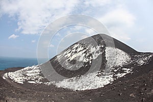 Horizontal shot of a Mount Krakatoa in Indonesia covered with snow under the white cloudy sky