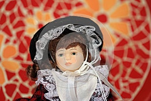 Horizontal shot of a porcelain doll in a white and black dress in a charity store