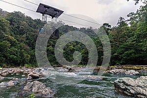 horizontal shot of a river with calm water with rafts in one in the middle of the jungle on the Pacuare River in Costa Rica with a