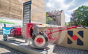 Horizontal shot of an simple vintage old red little tractor with two wheels