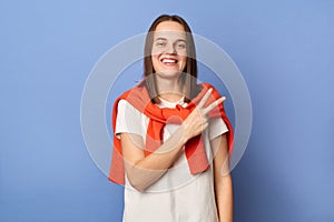 Horizontal shot of smiling satisfied young adult woman wearing casual style clothing, showing v sign, celebrating her success,