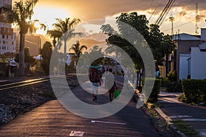 Horizontal shot of two backpackers tourists walking in the city of San Jose in Costa Rica with a sunset