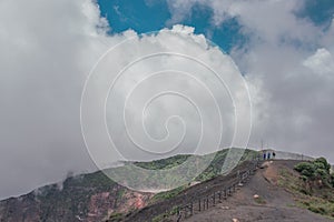 Horizontal shot of the viewpoint to the main crater surrounded with little vegetation rocky and sandy terrain with blue sky in the