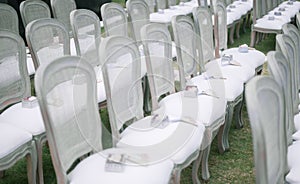 Horizontal shot of white chairs in the park for the wedding guests at daytime