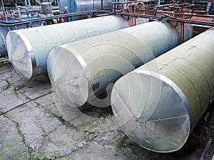 Horizontal storage tanks of chemical plant surrounded by pipeline valves and ladders